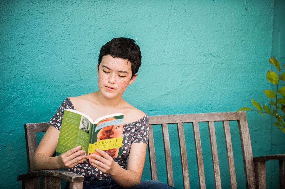 ati san francisco student sitting on a bench reading a book