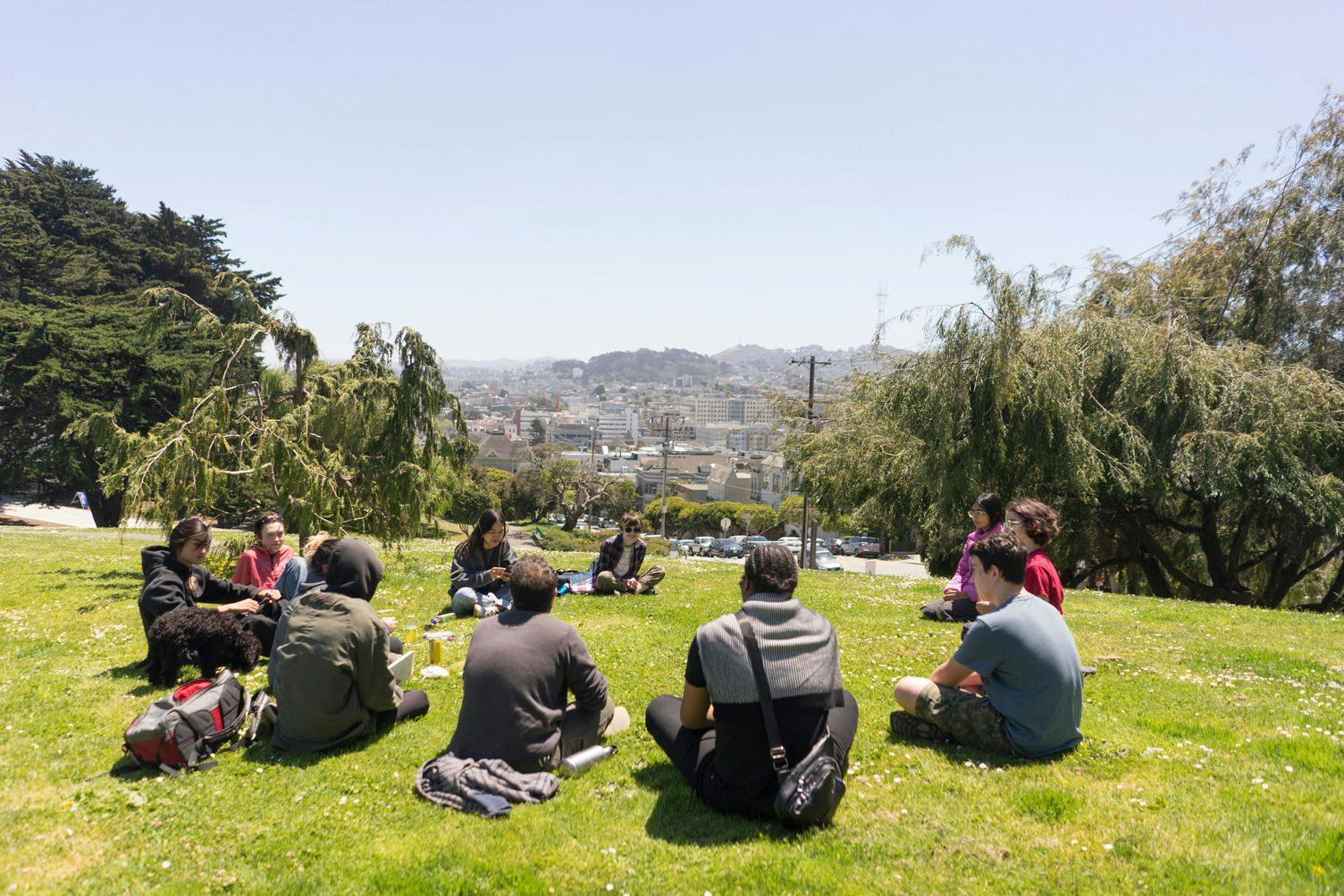 ATI San Francisco students sitting in a circle on grass having a discussion